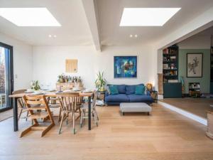a living room with a table and a blue couch at Pass the Keys London Spacious Dulwich family house with Pool in London