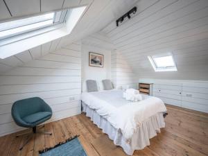 a bedroom with a bed and a blue chair at Pass the Keys London Spacious Dulwich family house with Pool in London +57 photos