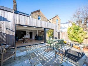 an open patio with a table and chairs at Pass the Keys London Spacious Dulwich family house with Pool in London