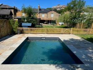 a swimming pool in a yard with a fence at Pass the Keys London Spacious Dulwich family house with Pool in London