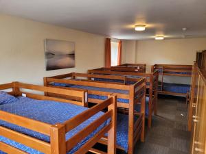 Cette chambre comprend une rangée de lits superposés en bois. dans l'établissement Woodlands Centre, à Betws-y-coed