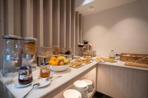 ein Frühstücksbuffet in einem Hotelzimmer mit Speisen in der Unterkunft Alfons Hotel in Ciutadella