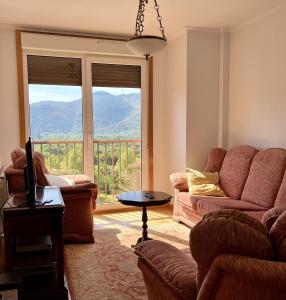 - un salon avec un canapé et une grande fenêtre dans l'établissement Precioso piso en el corazón de la Riveira Sacra, à Quiroga