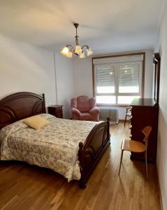 a bedroom with a bed and a chair and a desk at Preciosas vistas en el corazón de la Riveira Sacra in Quiroga +5 photos
