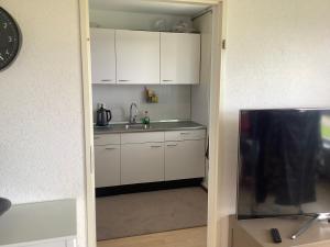 uma cozinha com armários brancos e um lavatório em Geniet van de rust en uitzicht em Haia