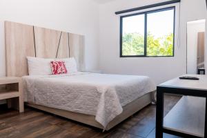 1 dormitorio con cama y ventana en Arkana 9 Suites Grupo Amber - Collection O en Playa del Carmen
