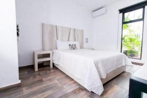 Habitación blanca con cama y ventana en Arkana 9 Suites Grupo Amber - Collection O en Playa del Carmen