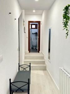 un pasillo con paredes blancas y escaleras con puerta en Apartamentos Val de Comillas, en Comillas