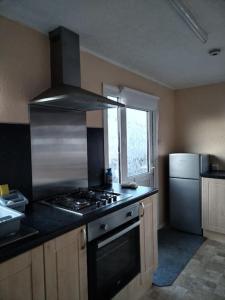 a kitchen with a stove top oven and a refrigerator at Fully refurbished holiday Chalet in withernsea in Withernsea
