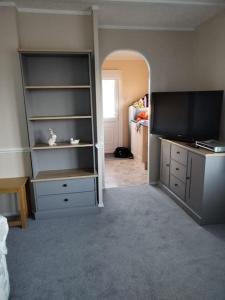 a living room with a tv and a room with a room at Fully refurbished holiday Chalet in withernsea in Withernsea