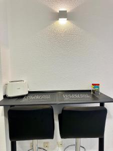 czarne biurko z dwoma krzesłami i drukarką w obiekcie Apartamentos Val de Comillas w mieście Comillas