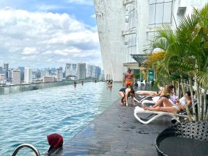 una piscina en la parte superior de un edificio con gente en el agua en Regalia Residence by skypool klcc, en Kuala Lumpur