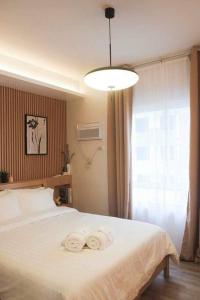 - une chambre avec un lit blanc et des serviettes dans l'établissement Xavioré - Mesavirre Garden BCD, à Bacolod