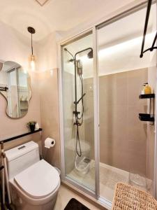 La salle de bains est pourvue de toilettes et d'une douche en verre. dans l'établissement Xavioré - Mesavirre Garden BCD, à Bacolod