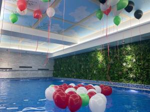 una piscina con globos rojos y blancos colgando del techo en Costa Del Sol Hotel by Arabian Link, en Kuwait