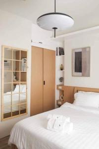 - une chambre avec un lit doté de draps blancs et d'une lampe dans l'établissement Xavioré - Mesavirre Garden BCD, à Bacolod