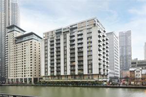 un rendimiento de un gran edificio junto a un río en Londwell, Canary Wharf River Thames Balcony Suite en Londres