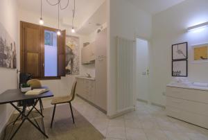 kuchnia ze stołem, krzesłem i biurkiem w obiekcie Imola Residence - Self Check-in w mieście Imola