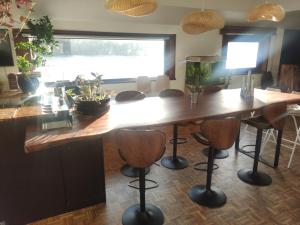 uma cozinha com uma grande mesa de madeira com bancos de bar em Experience Paris 2024 from la Seine em Villeneuve-la-Garenne