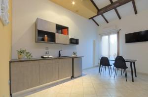 kuchnia z blatem i krzesłami w pokoju w obiekcie Imola Residence - Self Check-in w mieście Imola