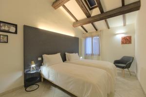 1 dormitorio con 2 camas y 1 silla en Imola Residence - Self Check-in en Imola