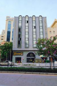 ein großes Gebäude an einer Straße in einer Stadt in der Unterkunft Liberty Avenue Hotel in Doha