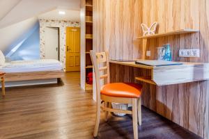 Habitación pequeña con escritorio y cama en Hotel Folklorehof, en Chemnitz
