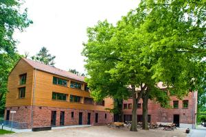 ein Gebäude mit einem Baum davor in der Unterkunft Umwelt Bildungszentrum Berlin in Berlin