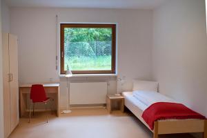 sypialnia z łóżkiem, oknem i biurkiem w obiekcie Umwelt Bildungszentrum Berlin w Berlinie