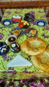 una mesa con platos de comida encima en Guest House Muborak, en Samarkand