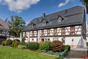 a large white house with a black roof at Hotel Folklorehof in Chemnitz