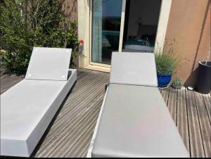 2 bancs blancs assis sur une terrasse couverte dans l'établissement CHAMBRE D HOTE, à Porticcio