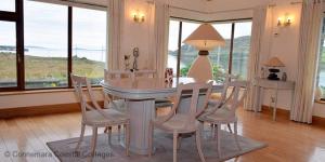 jadalnia ze stołem i krzesłami z widokiem w obiekcie Cleggan 318 Atlantic Lodge w mieście Cleggan