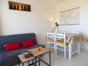 uma sala de estar com um sofá azul e uma mesa em Charmant appartement T2 avec Balcon em Saint-Cyprien