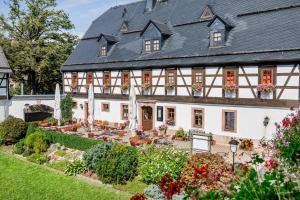 ein großes Haus mit Garten davor in der Unterkunft Hotel Folklorehof in Chemnitz