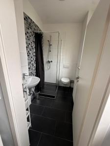 La salle de bains est pourvue d'une douche, d'un lavabo et de toilettes. dans l'établissement Domum 9 Moderne Ferien- Monteurapartments inkl Wlan und Waschmaschine, à Marl