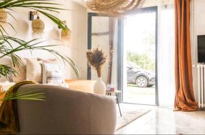 sala de estar con sofá y puerta corredera de cristal en Suite avec Jaccuzi, en Saintry-sur-Seine