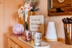 uma mesa com um vaso de flores e um cartaz em Hotel Folklorehof em Chemnitz