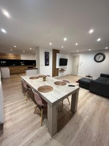 a large living room with a table and a couch at Grand loft calme et confortable en cœur de ville in Dunkerque
