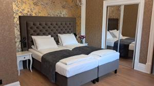 1 dormitorio con 1 cama grande y espejo en Oficerski Yacht Club, en Augustów