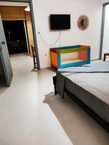 Cette chambre comprend un lit et une télévision à écran plat. dans l'établissement ΠΑΝΩ ΣΤΟ ΚΥΜΑ, à Salamine