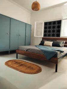 - une chambre avec 2 lits avec des armoires bleues et un tapis dans l'établissement ΠΑΝΩ ΣΤΟ ΚΥΜΑ, à Salamine