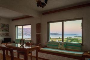 a living room with a couch and two large windows at Koriani Farm Cottage in Lixouri