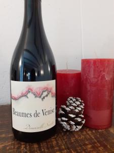 ボーム・ド・ヴニーズにあるauberge saint rochのろうそく横の赤ワイン1本