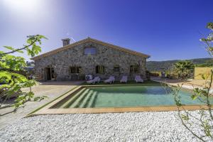a stone house with a swimming pool in front of it at HomeHolidaysRentals Karisma - Costa Barcelona in Argentona