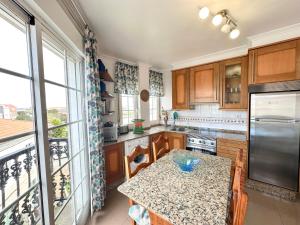 eine Küche mit Holzschränken und einem Tisch mit Arbeitsplatte in der Unterkunft Casa Ana in O Grove