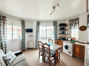 eine Küche und ein Wohnzimmer mit Tisch und Stühlen in der Unterkunft Casa Ana in O Grove