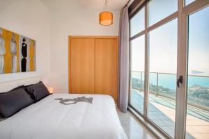 um quarto com uma cama e uma grande janela em Luxury Penthouse on the 42nd floor with amazing sea views em Benidorm
