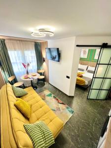 sala de estar con sofá amarillo y dormitorio en Elegante Apartamento TRES COLORES, en Alicante