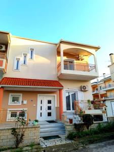 Dieses weiße Haus verfügt über eine Veranda und einen Balkon. in der Unterkunft Nikola's apartments_King Pyrros in Palio Limani